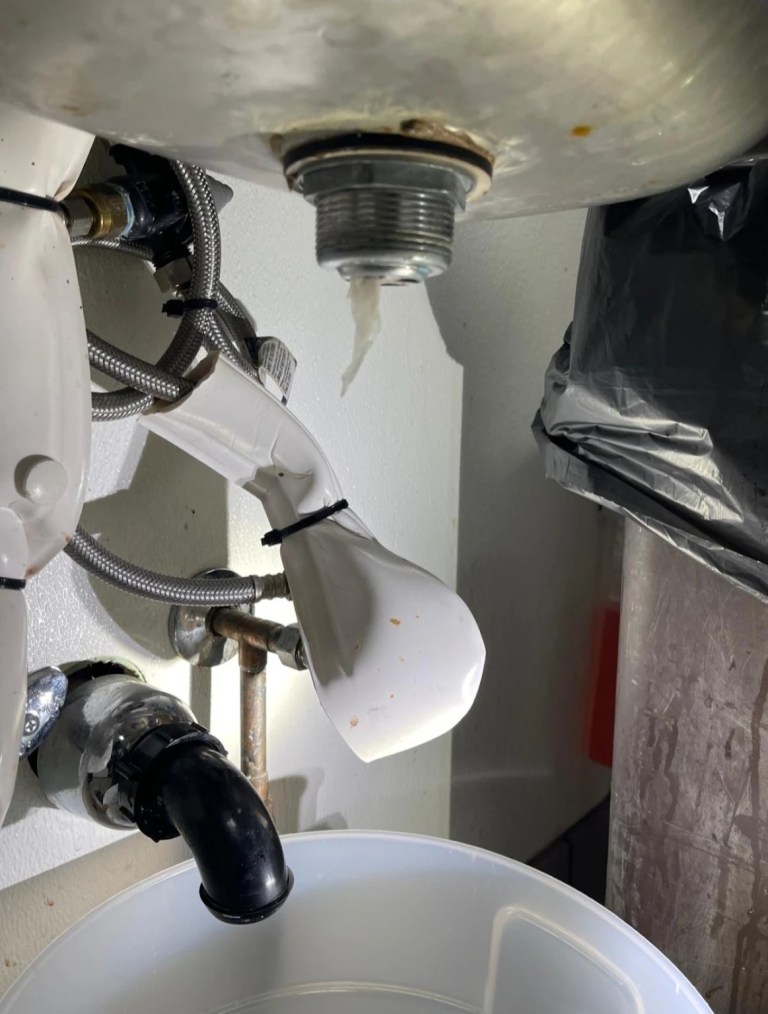 Commercial sink drain assembly being removed during repair at Vampire Penguin in Ontario, California